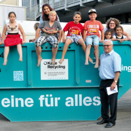 Jürgen Karle vor Mulde mit fröhlichen Kindern 